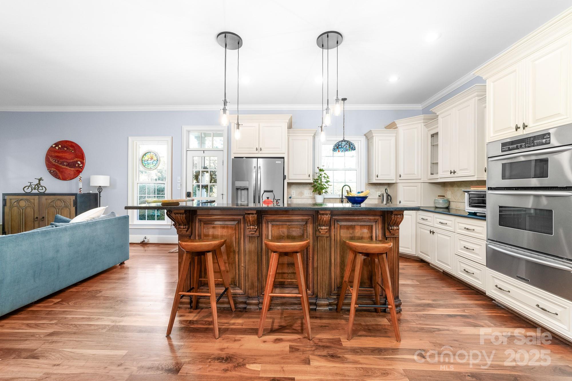 200 Galey Ridge Cramerton, NC 28032 - Photo 12 of 48 a kitchen with stainless steel appliances granite countertop wooden floor dining table chairs and view of living room