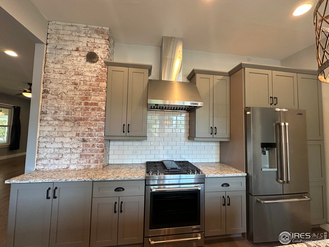 302 Beattie Street Sterling, CO 80751 - Photo 11 of 30 a kitchen with stainless steel appliances granite countertop a refrigerator a stove and a sink with wooden floor