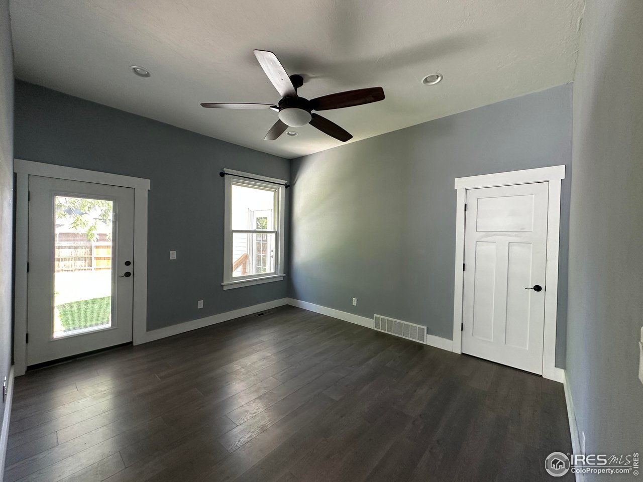 302 Beattie Street Sterling, CO 80751 - Photo 14 of 30 a view of an empty room with wooden floor and a window