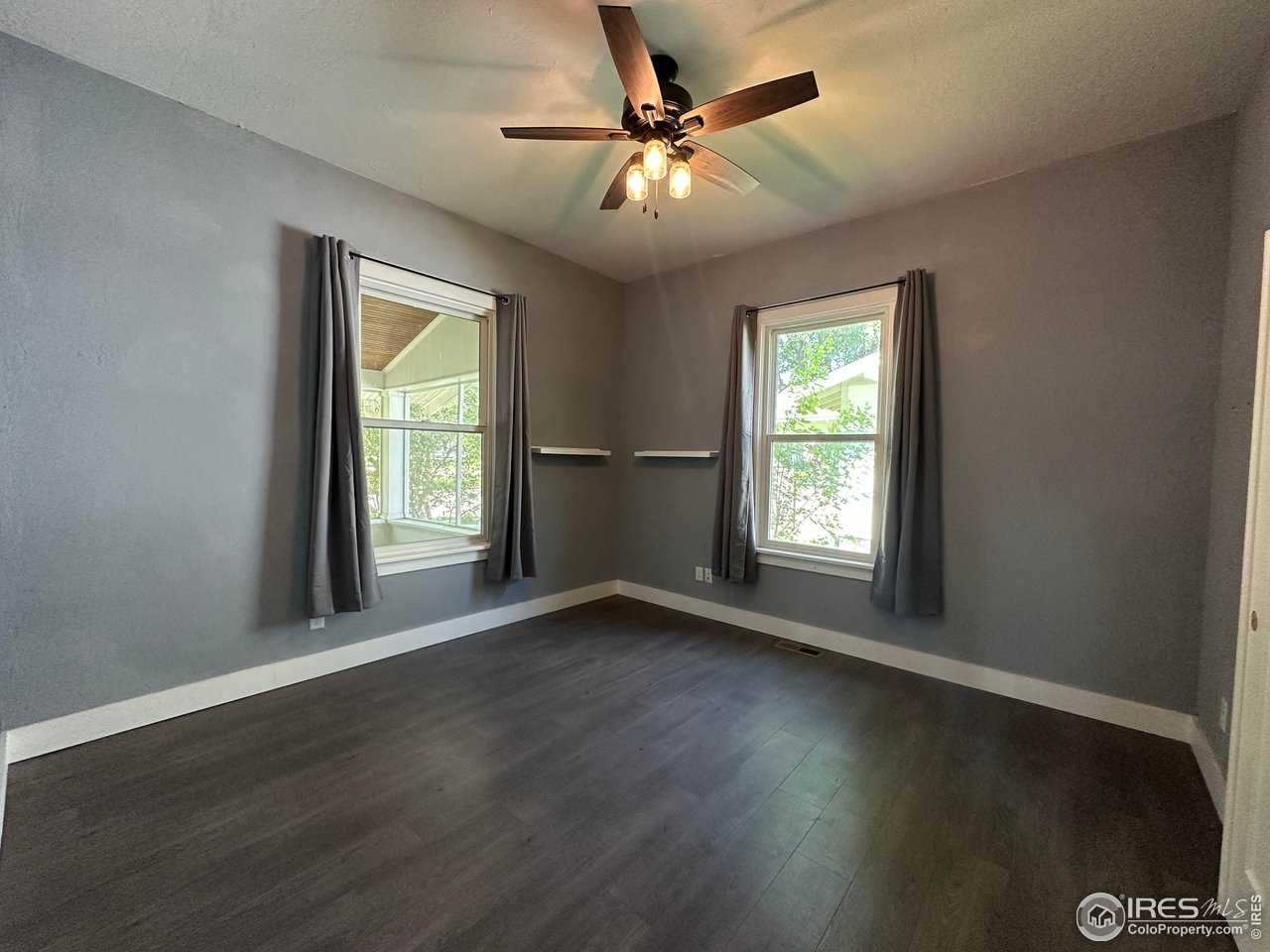 302 Beattie Street Sterling, CO 80751 - Photo 24 of 30 a view of an empty room with wooden floor and a window