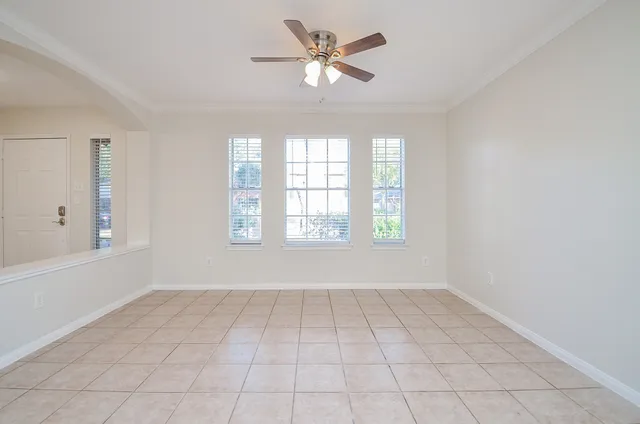 a view of an empty room with a chandelier fan