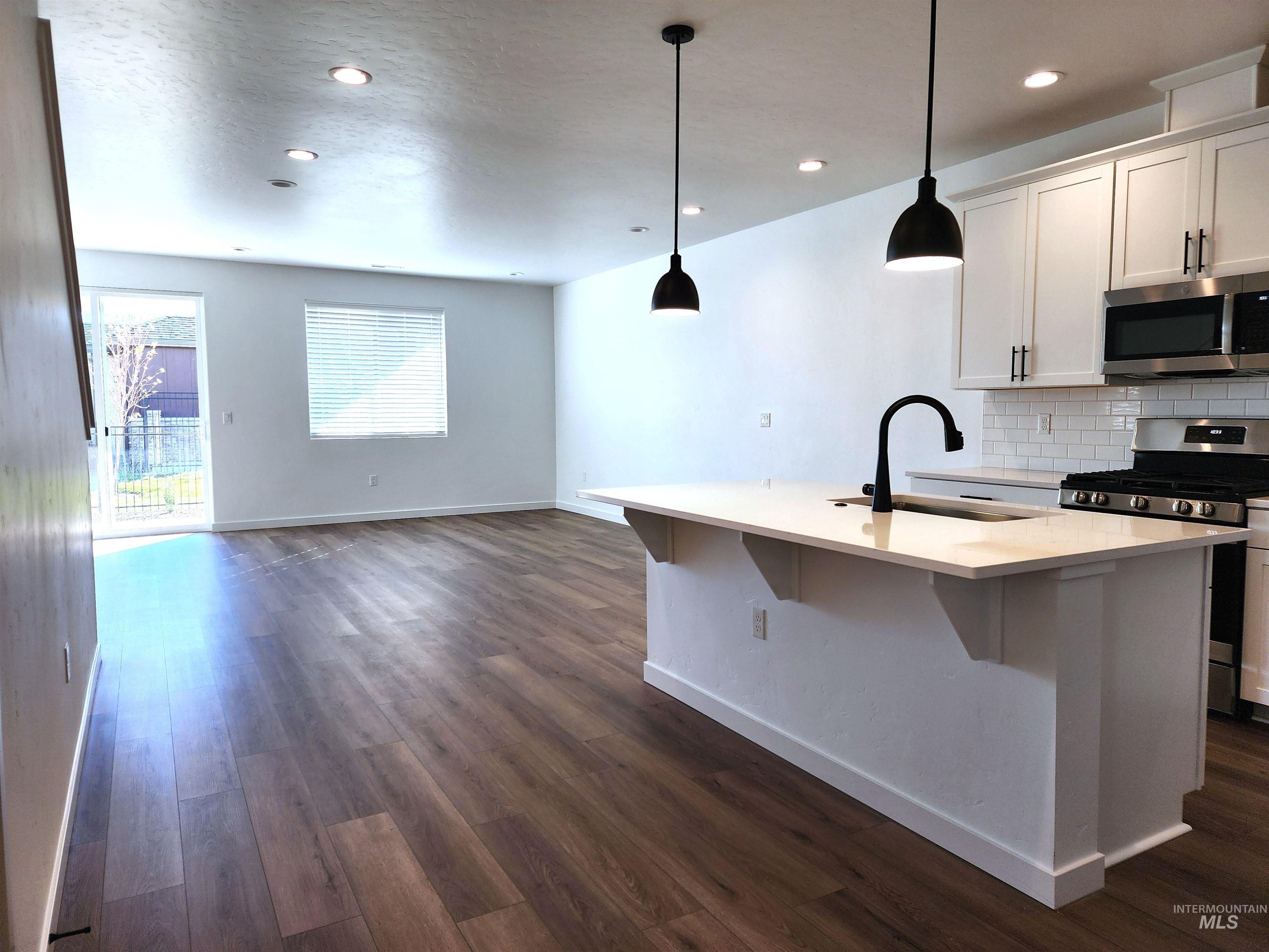 362 North Lagrasse Lane Star, ID 83669 - Photo 16 of 16 Kitchen featuring appliances with stainless steel finishes, backsplash, dark wood finished floors, open floor plan, and recessed lighting