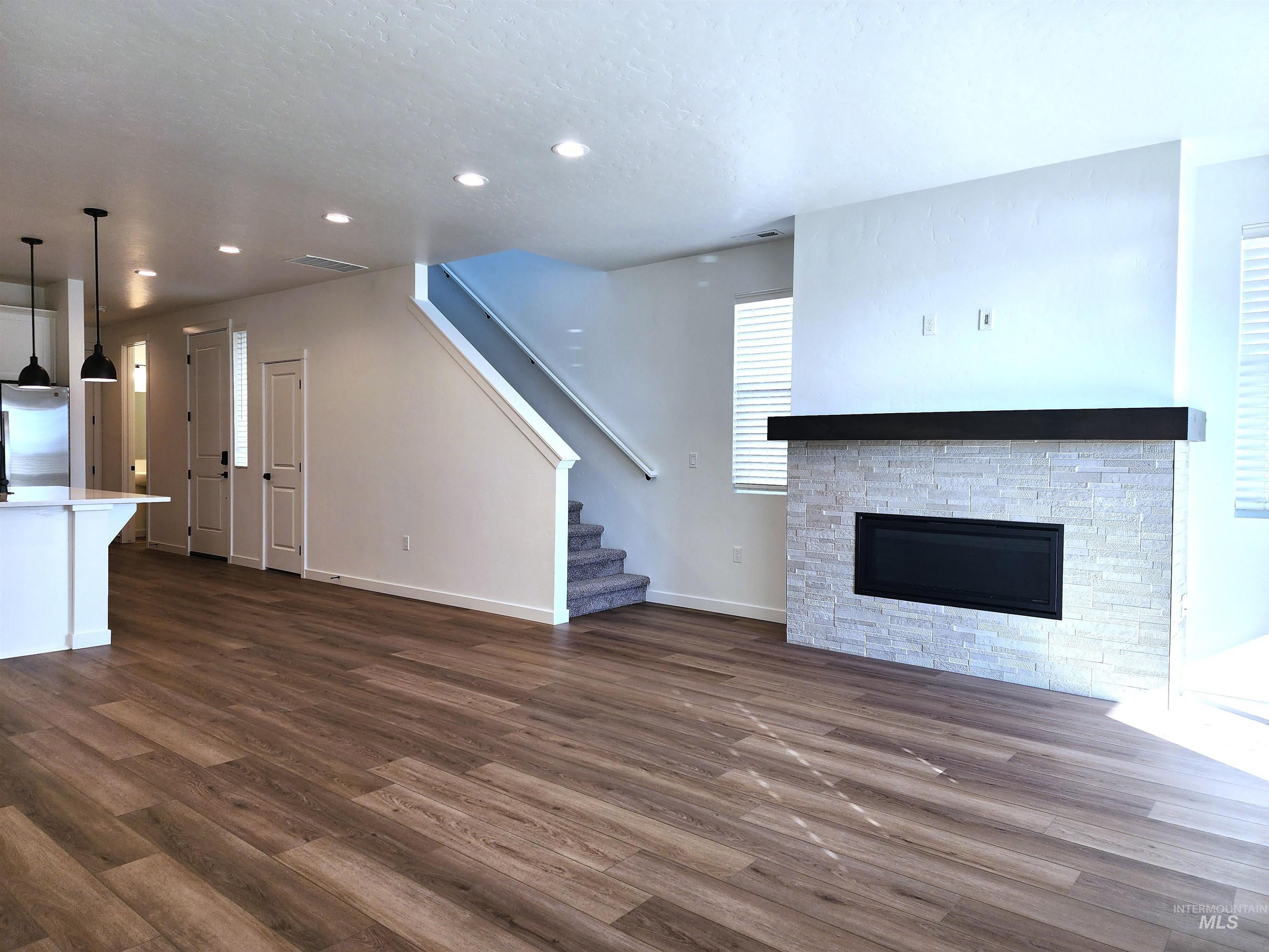 362 North Lagrasse Lane Star, ID 83669 - Photo 3 of 16 Unfurnished living room featuring a fireplace, stairway, dark wood-style floors, and recessed lighting