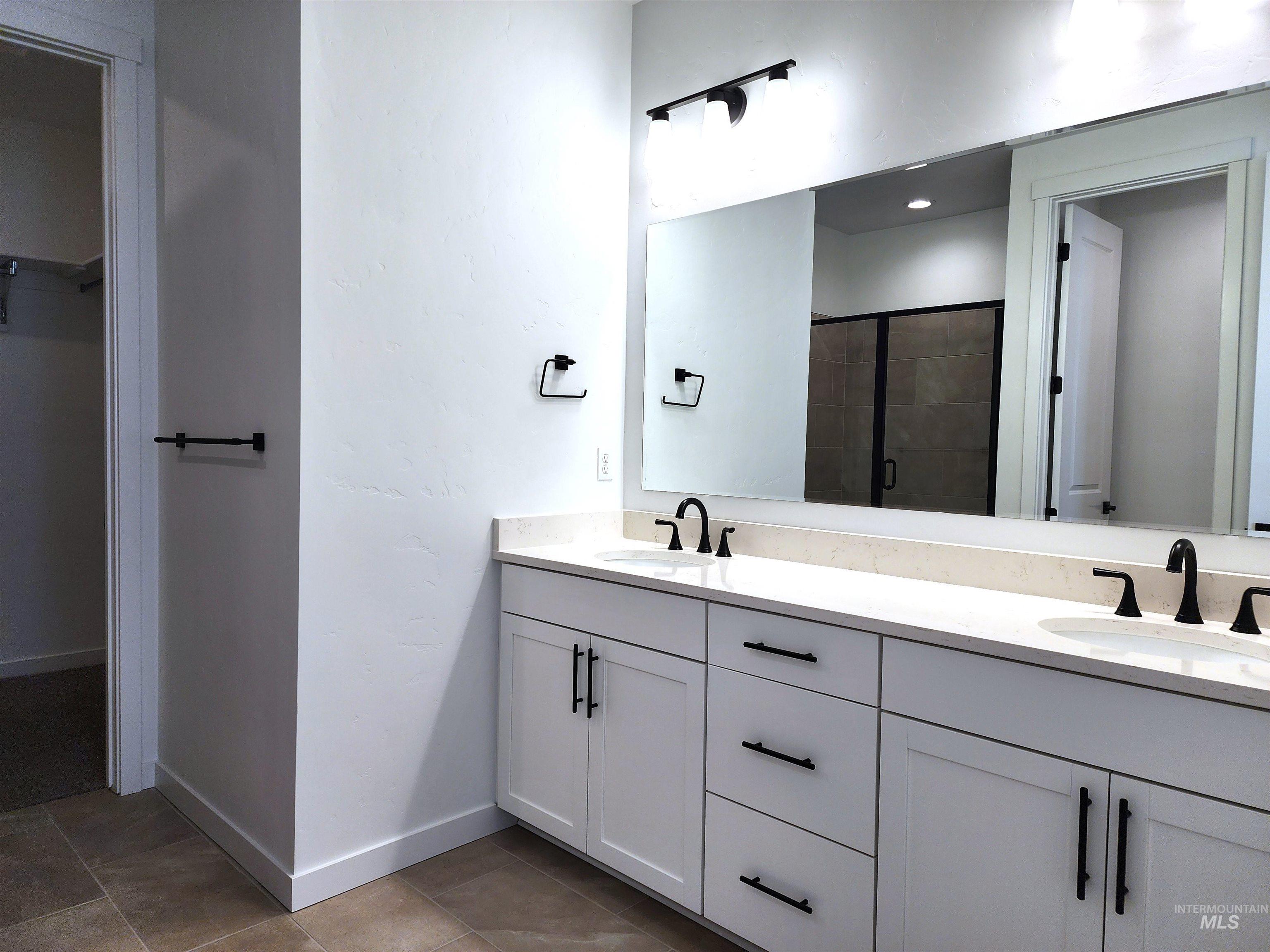 362 North Lagrasse Lane Star, ID 83669 - Photo 7 of 16 Full bathroom with a walk in closet, double vanity, a shower stall, and light tile patterned floors