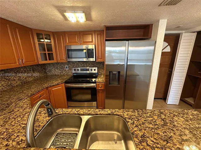 a kitchen with a refrigerator and a sink