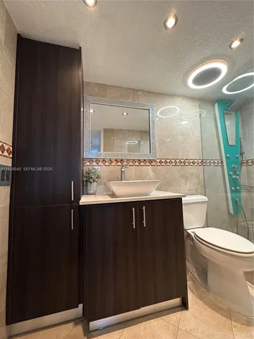 a bathroom with a sink vanity mirror and toilet