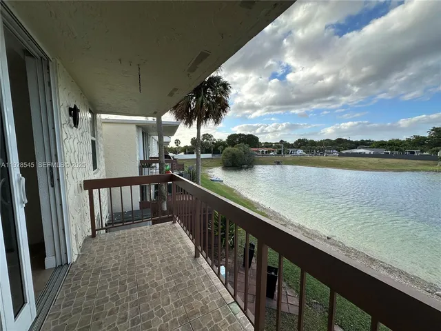 a view of a balcony with wooden floor and fence