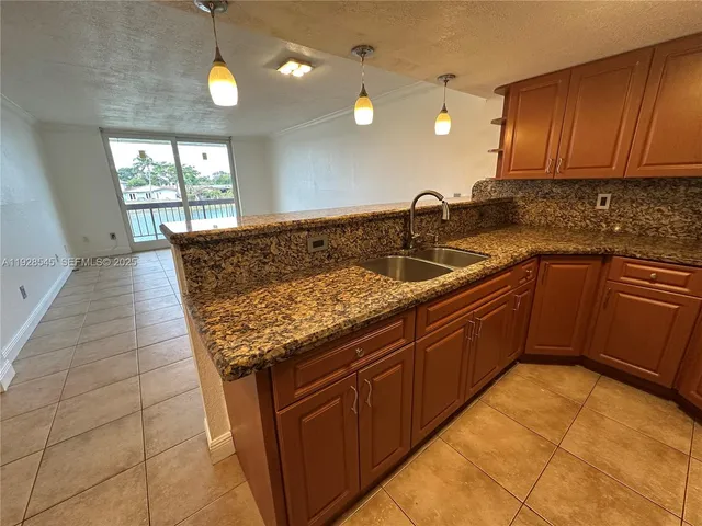 a kitchen with granite countertop a sink and a stove