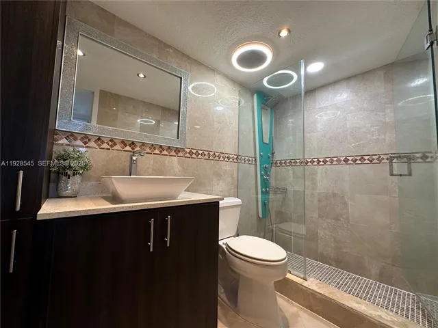 a bathroom with a sink mirror toilet and shower
