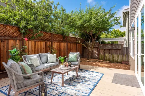 a view of a backyard with a large tree and wooden fence