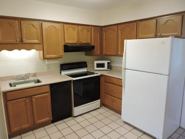 a kitchen with a refrigerator sink and cabinets