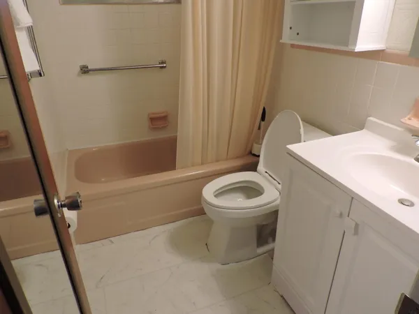 a white toilet sitting next to a bath tub