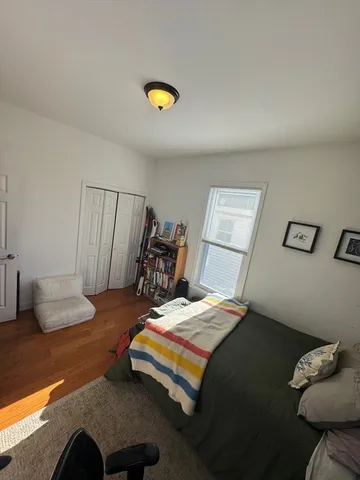 a bedroom with a bed and a lamp on desk