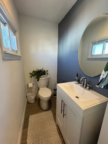 a bathroom with a toilet sink and mirror