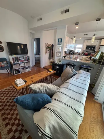 a living room with furniture kitchen view and a window