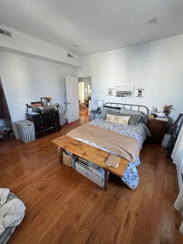 a bedroom with a bed and wooden floor