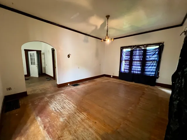 a view of an empty room with a fireplace and a window
