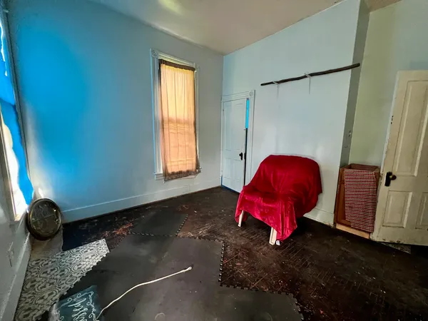 a bed sitting in a bedroom next to a window