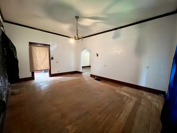 a view of an empty room with a window and a fireplace
