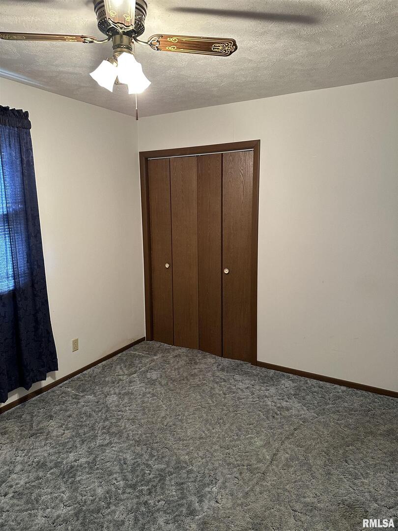 7863 Idyle Wild Road Du Quoin, IL 62832 - Photo 12 of 18 an empty room with a chandelier fan and closet
