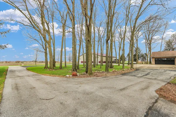 a view of a house with a big yard and large trees