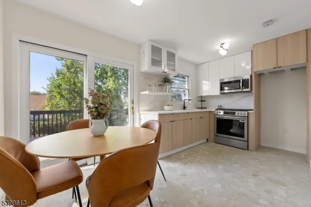 a kitchen with a table chairs microwave and cabinets
