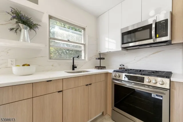 a kitchen with stainless steel appliances a stove a sink and a microwave