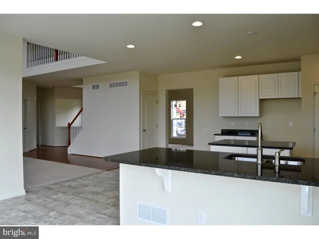 a kitchen with kitchen island granite countertop a sink stainless steel appliances and cabinets