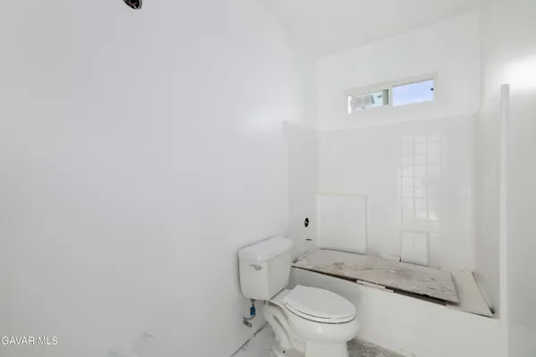 a bathroom with a granite countertop toilet and a shower