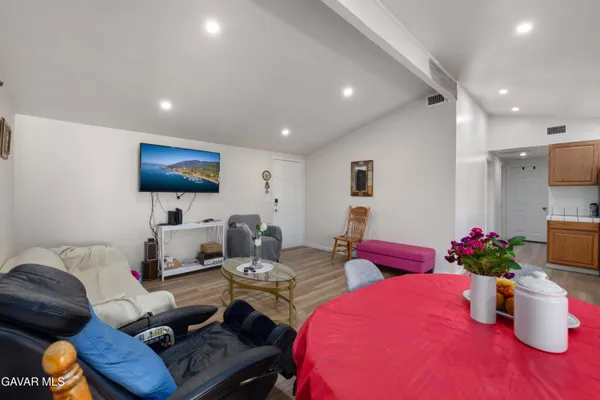 a living room with furniture a flat screen tv and a potted plant