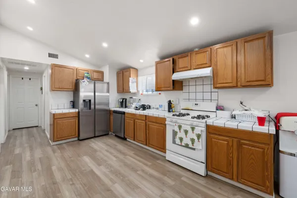 a kitchen with stainless steel appliances granite countertop a stove cabinets sink and refrigerator