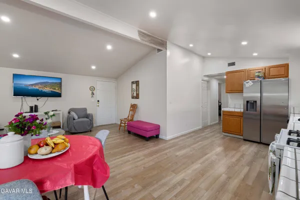 a kitchen with granite countertop a table chairs stove and refrigerator