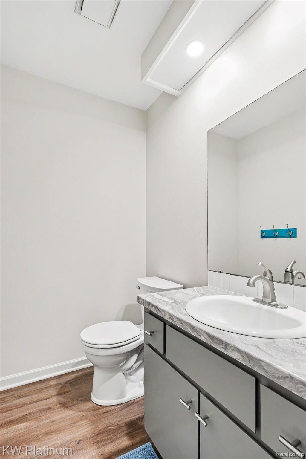 1700 River Road, Unit 6 Marysville, MI 48040 - Photo 17 of 32 Bathroom featuring a single vanity with a white oval sink, brushed nickel faucet, and a gray cabinet with silver pulls