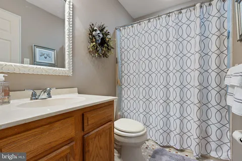 a bathroom with a granite countertop sink and a toilet