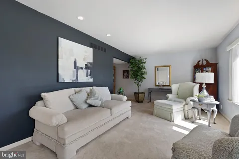 a living room with furniture white walls and a lamp