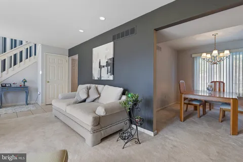 a living room with furniture and a chandelier