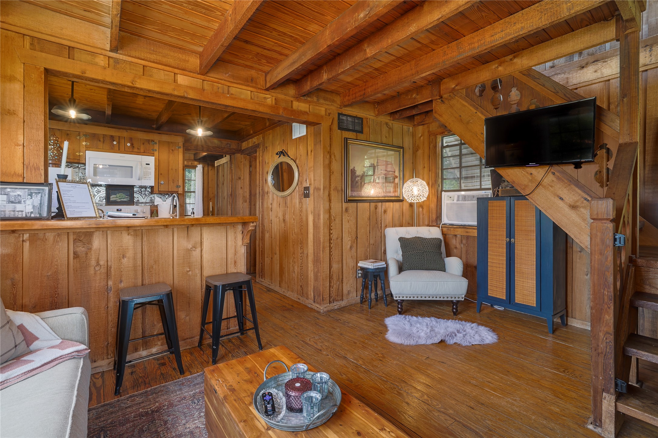 16800 Forest Way Austin, TX 78734 - Photo 15 of 15 A warm living space features rich wood paneling, exposed beam ceilings, and a convenient kitchen bar.