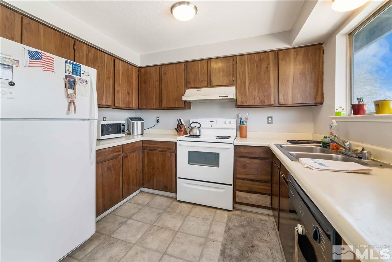 6806 Flower Street Reno, NV 89506 - Photo 8 of 26 a kitchen with a white stove top oven sink and cabinets