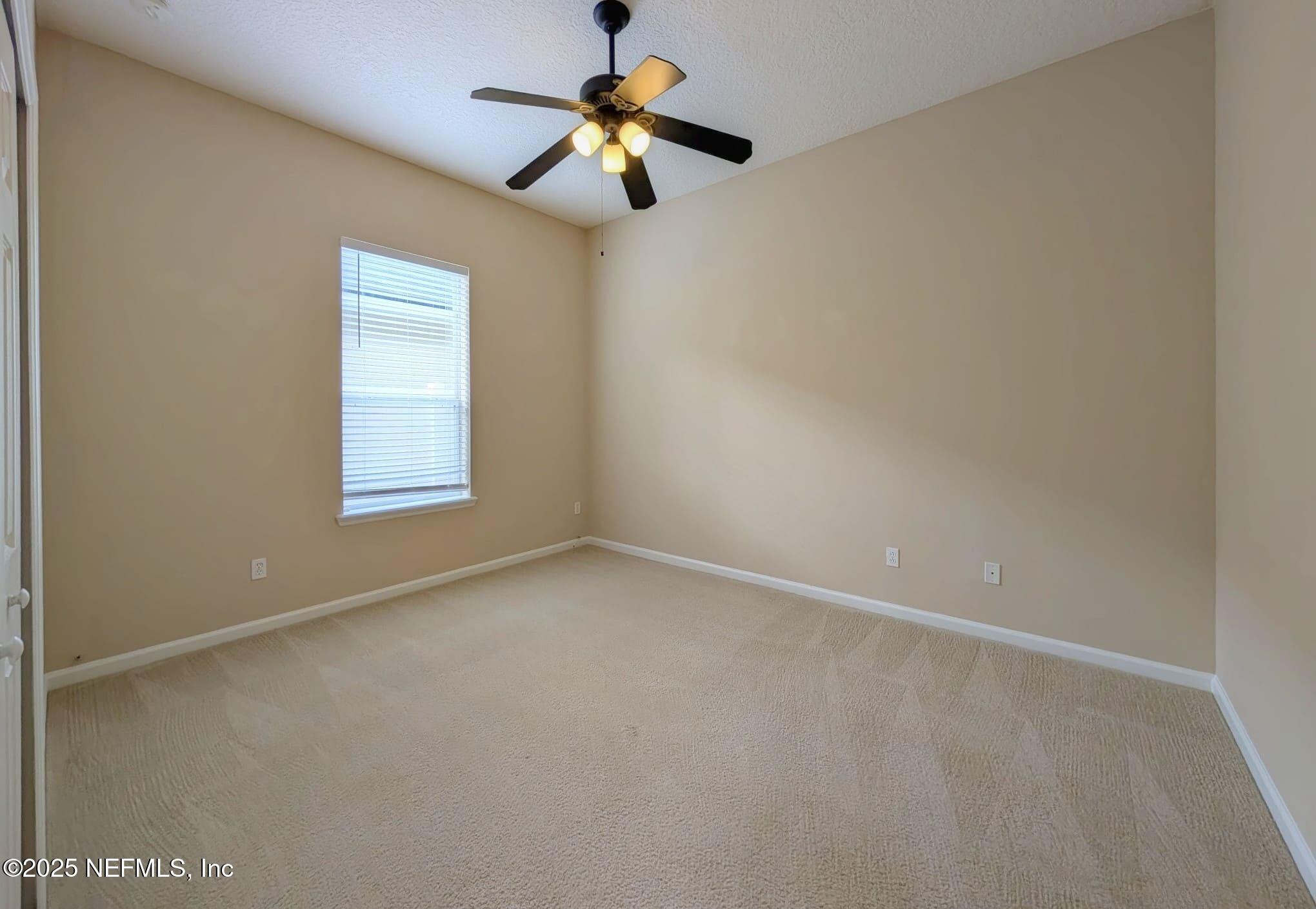 5871 Brush Hollow Road Jacksonville, FL 32258 - Photo 17 of 40 an empty room with a window and a fan