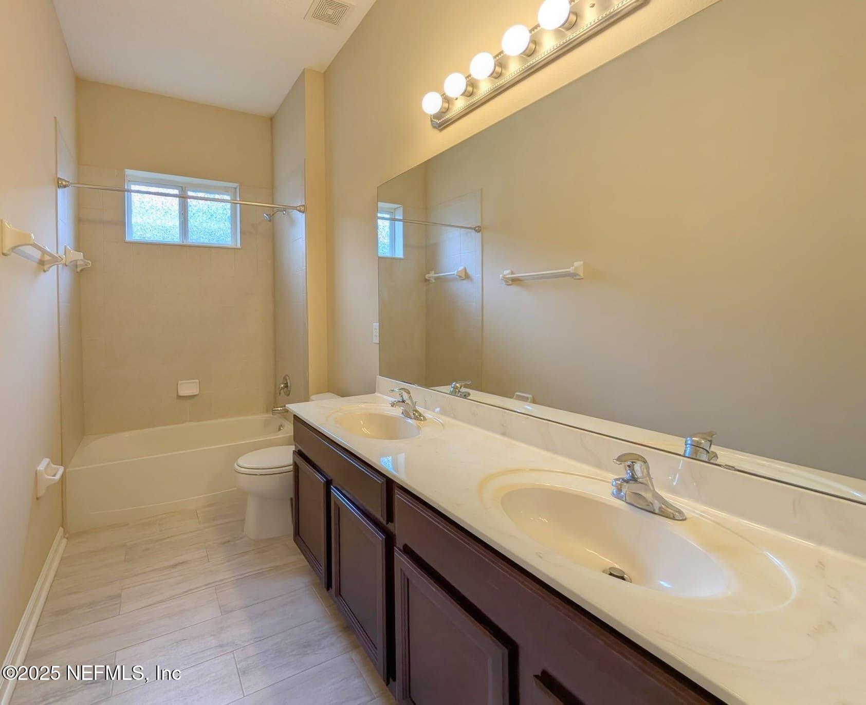 5871 Brush Hollow Road Jacksonville, FL 32258 - Photo 18 of 40 a bathroom with a granite countertop sink a toilet and shower