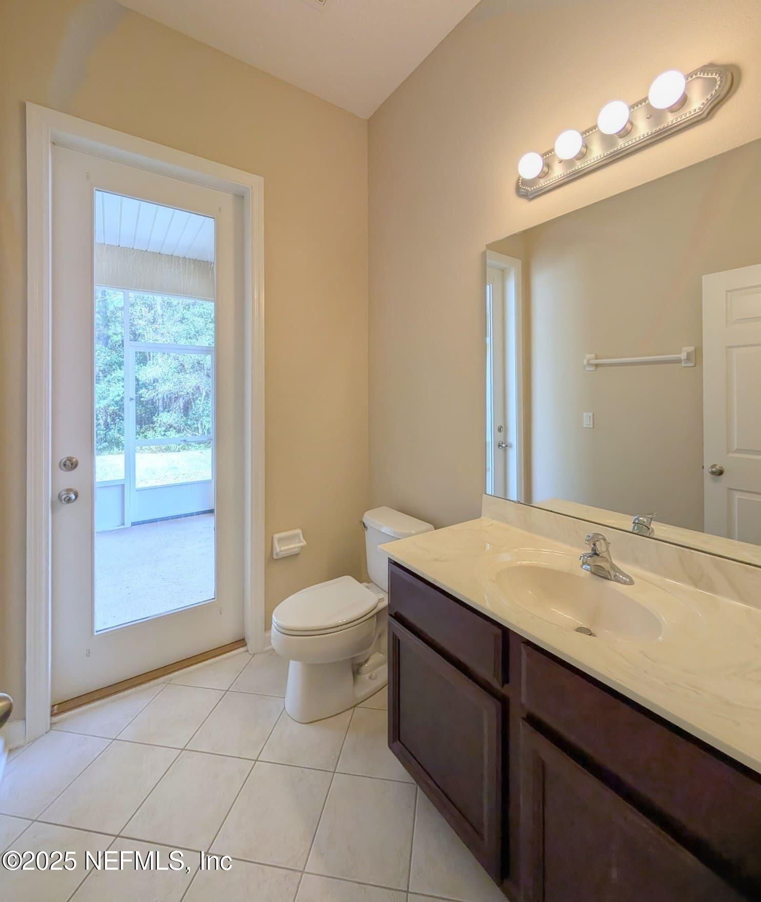 5871 Brush Hollow Road Jacksonville, FL 32258 - Photo 19 of 40 a bathroom with a granite countertop sink a toilet and a mirror
