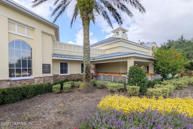 a front view of a house with a yard and potted plants