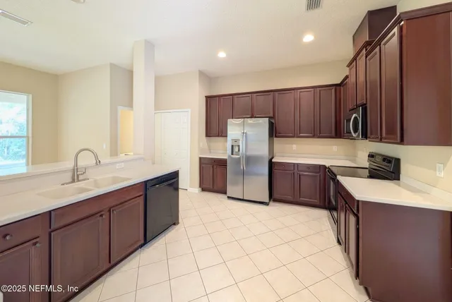a kitchen with stainless steel appliances a sink cabinets and a refrigerator