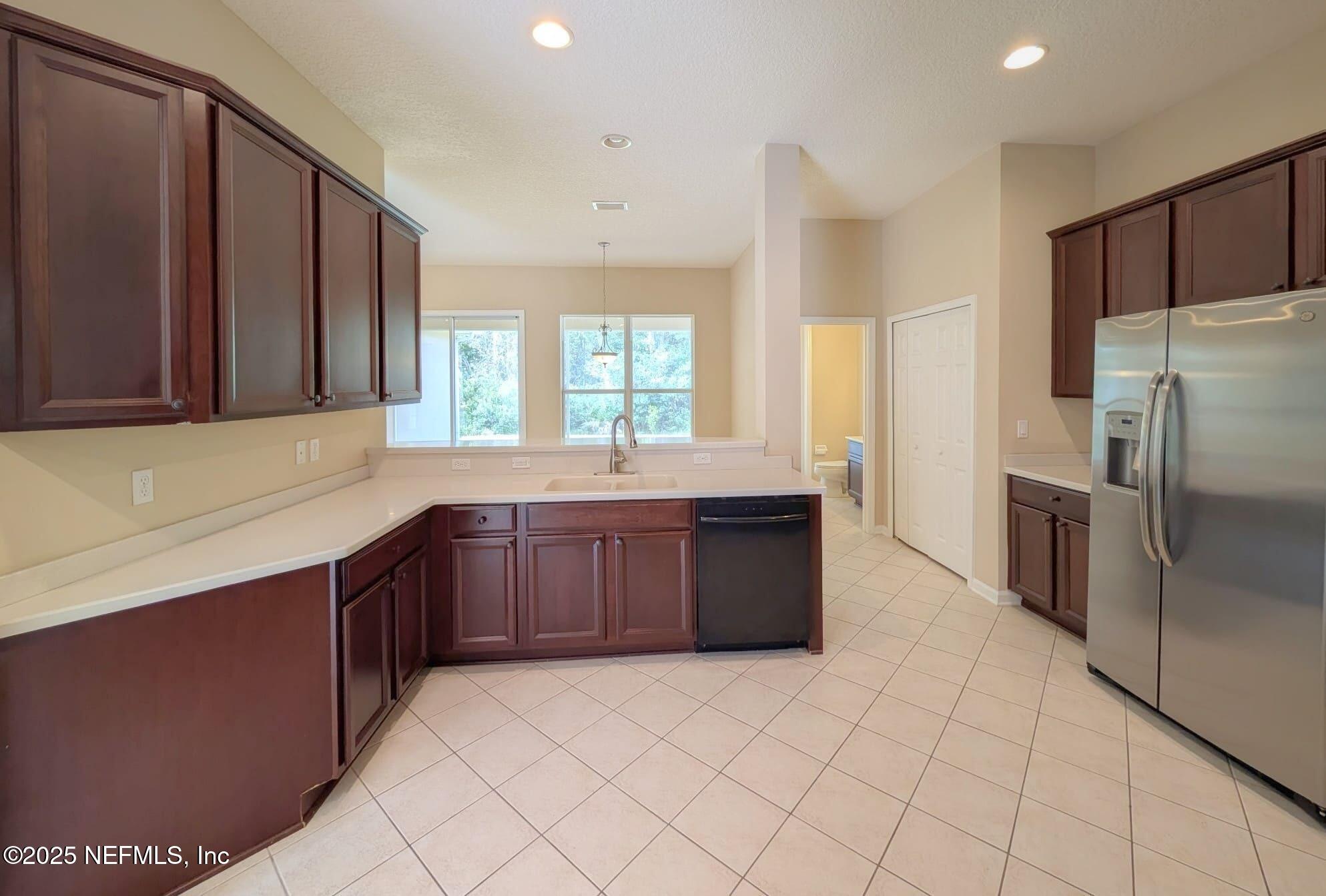 5871 Brush Hollow Road Jacksonville, FL 32258 - Photo 4 of 40 a large kitchen with granite countertop a refrigerator and a sink