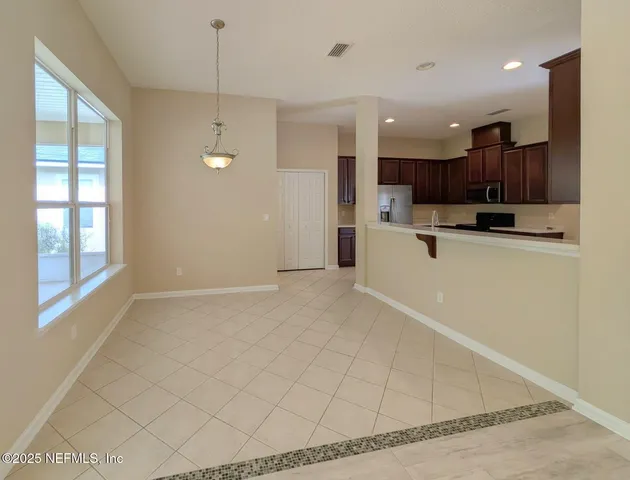 a view of kitchen with kitchen island white cabinets and refrigerator