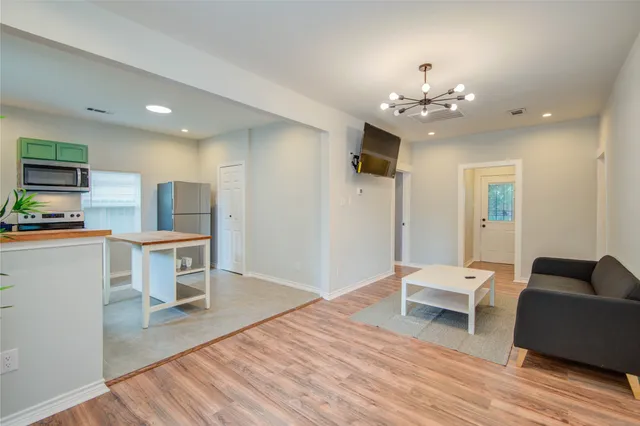 a living room with furniture and a chandelier