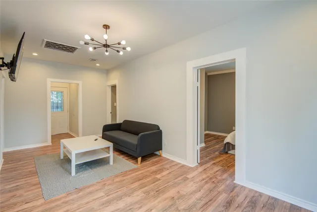 a living room with furniture and a wooden floor