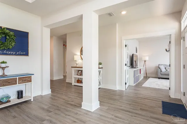 a view of a hallway with wooden floor and a living room