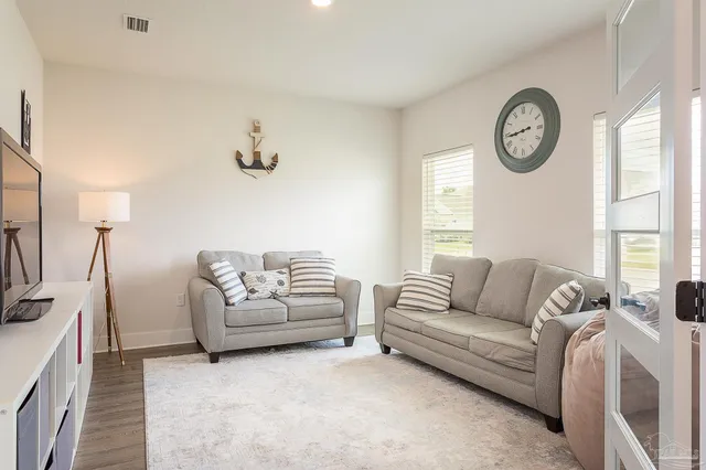 a living room with furniture a clock and a window