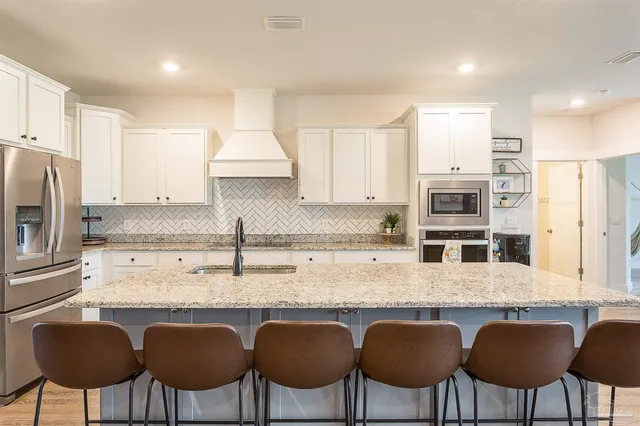 a kitchen with granite countertop white cabinets and chairs